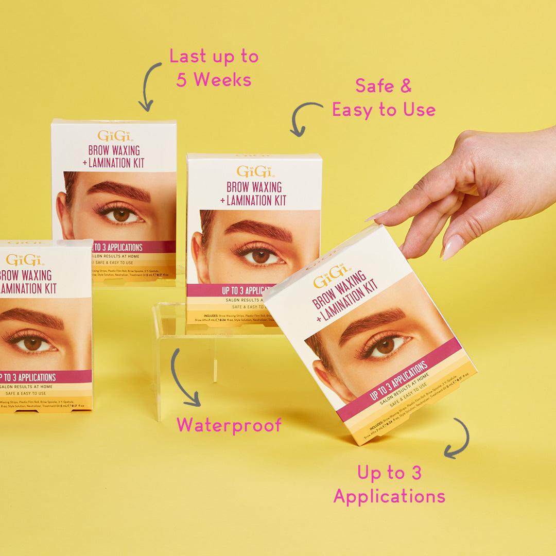 GIGI brow waxing and lamination kit packaging with a hand holding one of the kits on a yellow background.