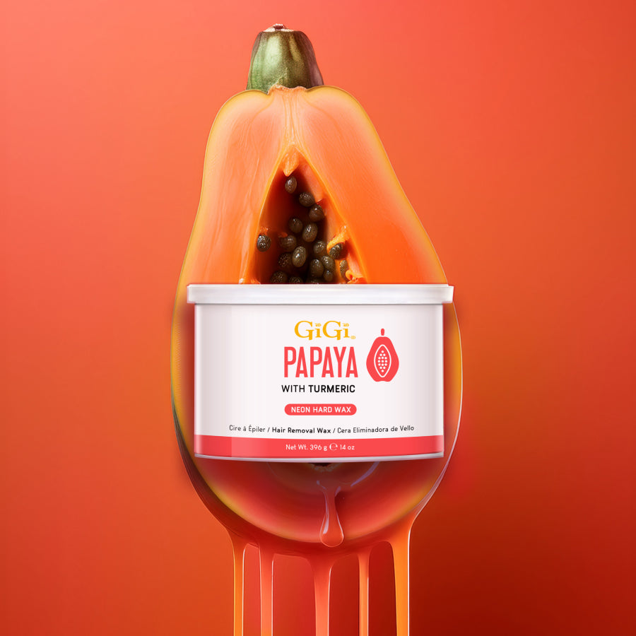 Papaya with a container of GiGi Papaya with Turmeric wax on an orange background