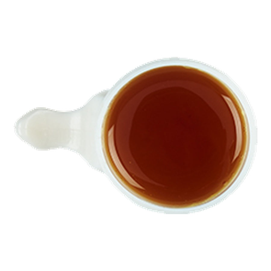 White ceramic scoop filled with brown liquid on a white background