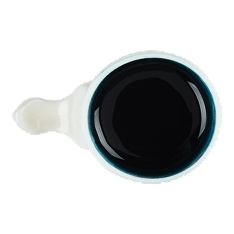 Ceramic scoop with dark wax on a white background