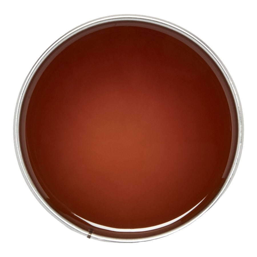 Brown wax swatch in a round container with a white background