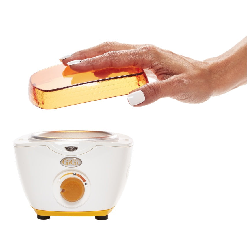 Hand holding a yellow lid over a Mini Honee Warmer on a white background