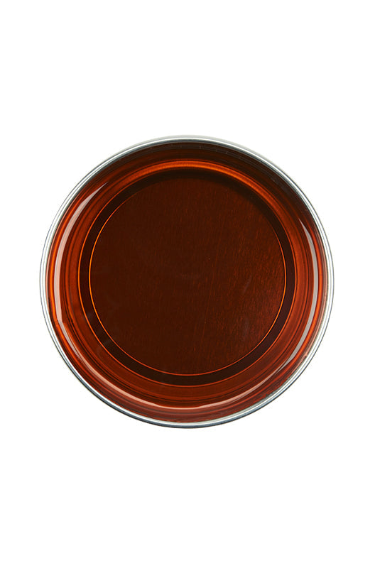 Top view of an open 14 ounce can of GiGi All Purpose Honee Soft showing its deep translucent brown color