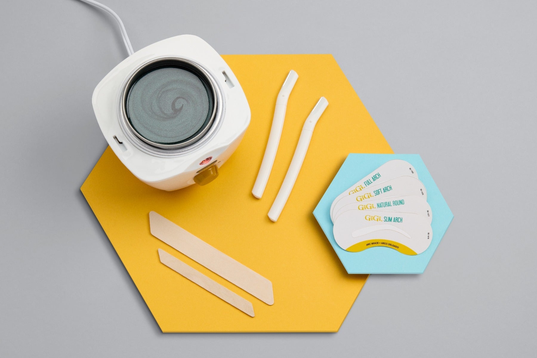 Mini Honee Wax Warmer, 2 Brow Razors, 4 Brow Stencils, 1 Small Accu Edge Applicator, 1 Large Accu Edge Applicator displaced outside packaging 